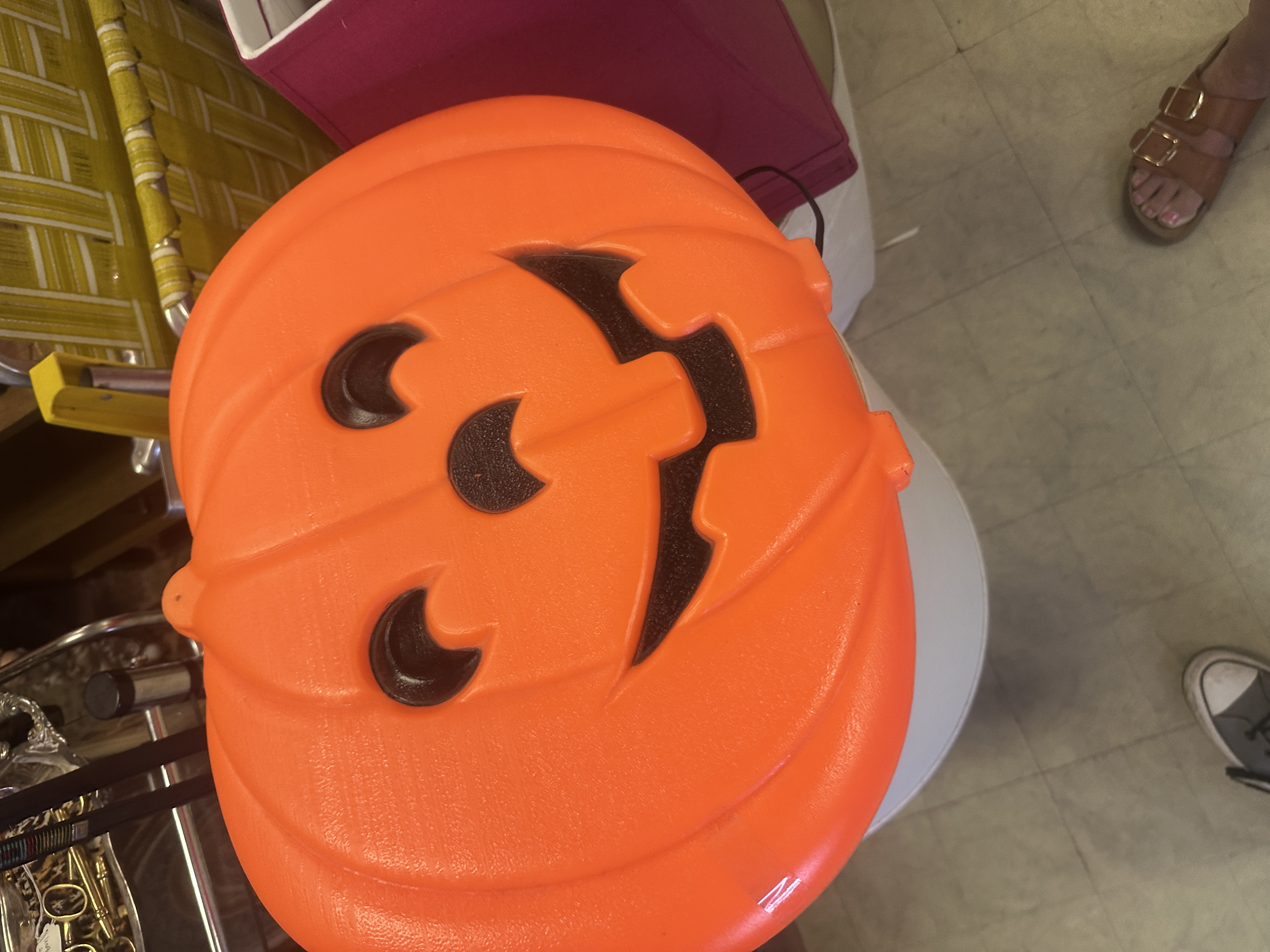 Orange plastic jack-o-lantern candy pail photographed in store