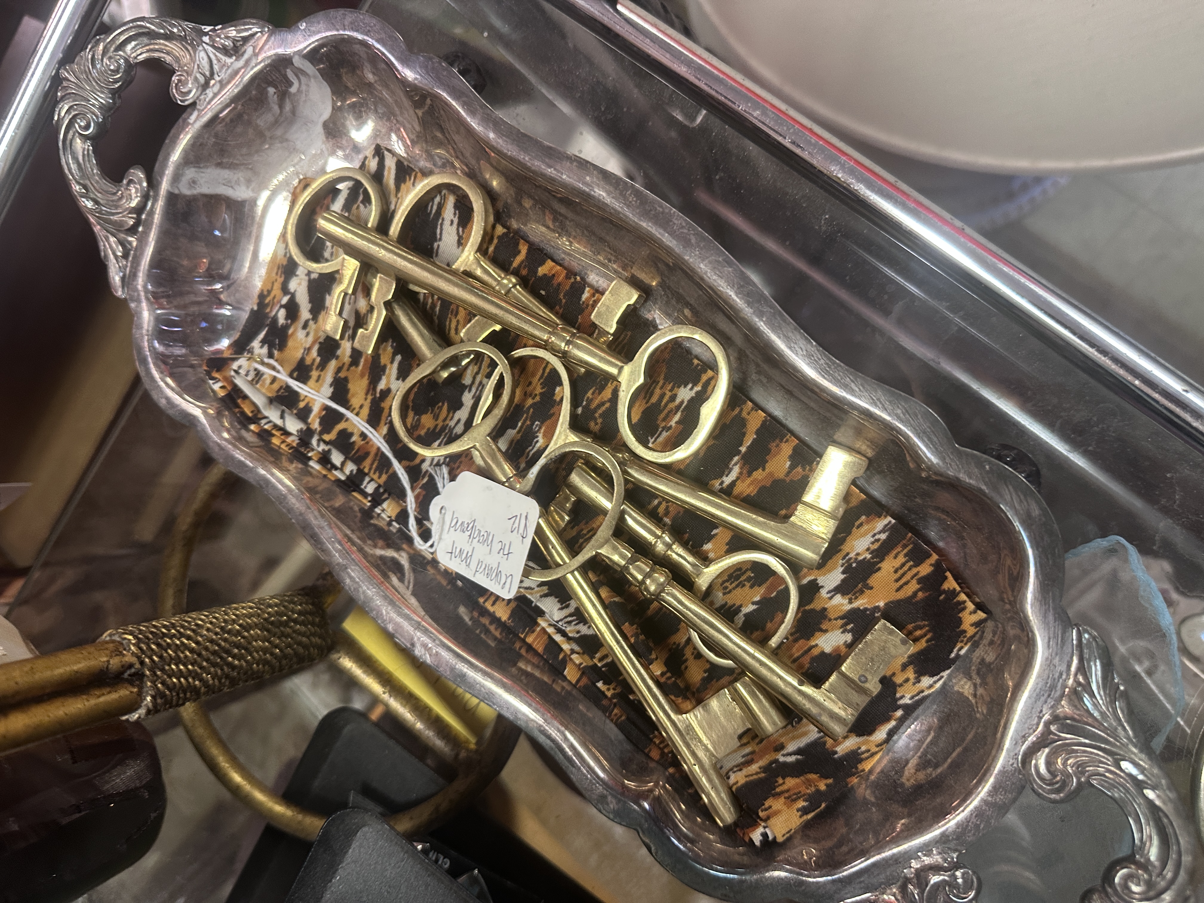 Brass skeleton keys arranged inside an ornate silver tray
